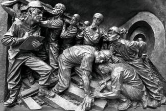 A metal statue of workers working