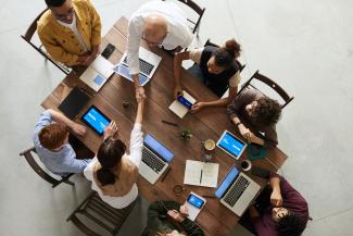 A group of people shaking hands at a table.