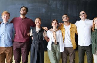 A diverse group of people with arms interlocked